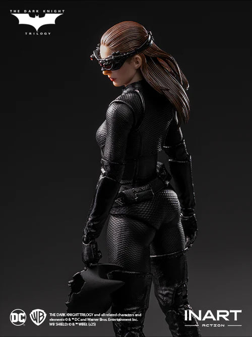 Action figure of a character in dark costume with mask, standing against a black background with 'The Dark Knight Trilogy' branding.