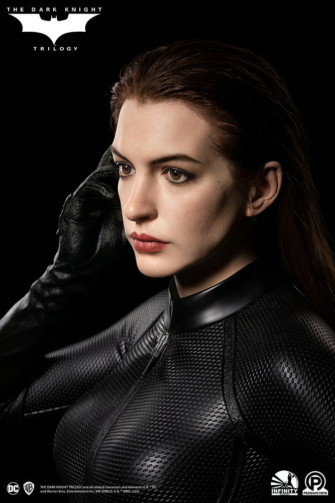 Person in a black superhero costume with a dark background, featuring 'The Dark Knight' Trilogy logo. The Dark Knight Rises Catwoman (Selina Kyle) 1:1 Scale Life-Size Masterpiece Bust by Infinity Studio x Penguin Toys