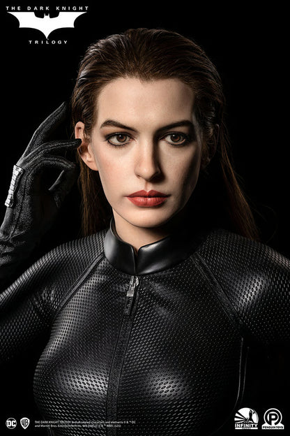 Character in a black suit with a dark background, featuring the 'The Dark Knight' Trilogy logo. The Dark Knight Rises Catwoman (Selina Kyle) 1:1 Scale Life-Size Masterpiece Bust by Infinity Studio x Penguin Toys