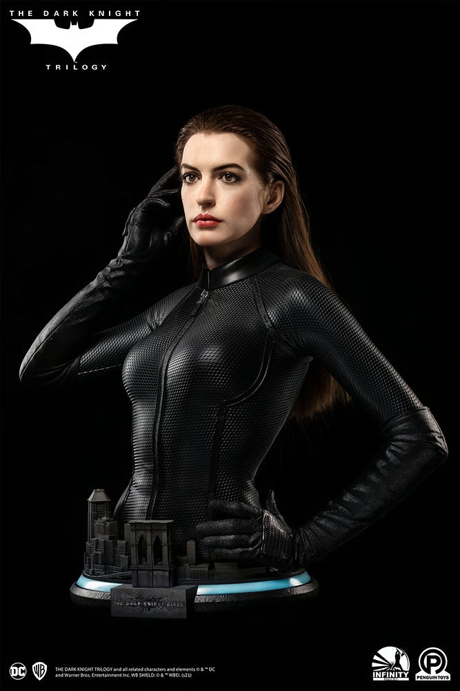 Statue of a character in a black suit with a dark background, featuring logos. The Dark Knight Rises Catwoman (Selina Kyle) 1:1 Scale Life-Size Masterpiece Bust by Infinity Studio x Penguin Toys